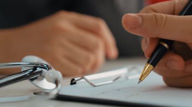 Hasta klinikte ya da hastane ofisinde doktor randevusuna gidiyor. Hastaların nabzını kontrol etmek için steteskoplu sendrom kayıtları yapılırken doktor semptomları inceler ve teşhis eder. Panorama. Katı.