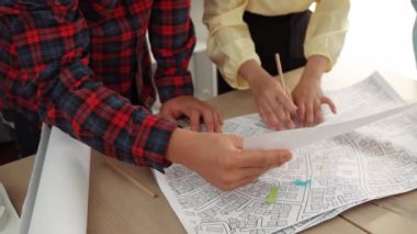 Mimari ekipmanlarla toplantı masasında ev tasarımı üzerine profesyonel mühendis ekibi tartışması ve modern ofiste bina planı dağılımı. Eline odaklan. - Yakın çekim. Tanımlama.