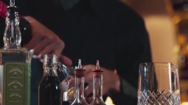 İçki şekerini ölçmek için elinde jigger tutan yakın el barmeni bardakları karıştırmak için alkol hazırlama yaratıcı karışım. Gece hayatı karışımı sergilenen özel bir içecek. Vinosity.