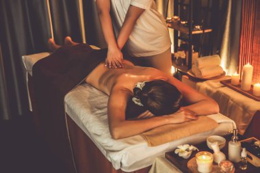 Beyaz kadın müşteri stres önleyici spa masajının keyfini çıkarıyor ve lüks otel ya da otelde sıcak mum ışığında güzellik teniyle eğleniyor. Sessiz.