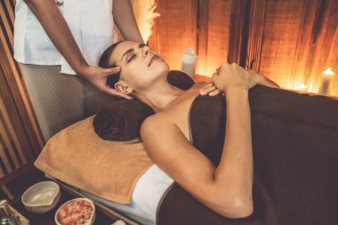 Beyaz kadın stres önleyici kafa masajı yapmaktan ve lüks otel veya otelde sıcak mum ışığında yüz güzelliği eğlencesi yapmaktan zevk alıyor. Sessiz.