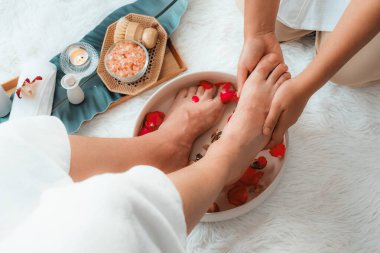 Kadınlar lüks spa salonlarında keyifli ayak masajlarına devam ederken, masör de hafif gün ışığı atmosferinde refleksoloji terapisi veya otel ayak spa 'sında. Sessiz.