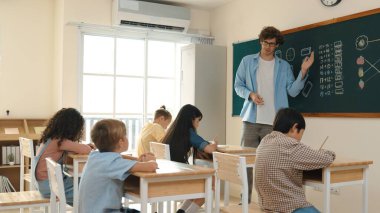 Öğrenci ödevlerine bakarken sınıfta yürüyen yetenekli bir öğretmen. Sınav yaparken ya da sınıfta ödev yaparken akıllı çocuk defterini kontrol eden profesyonel bir eğitmen. Pedagoji.