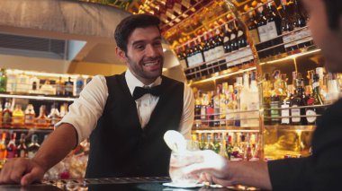 Akıllı barmen, lüks bir tezgahta arkadaşını beklerken limonlu cin kokteyli ikram ediyor. Barmen, canlı gece hayatı parti atmosferinde mükemmel hizmet veriyor. Vinosity.