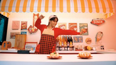 Profesyonel Asyalı restoran işçisi yemek hazırlar ve yemek barının arkasında durur. Kırmızı gömlekli ve kırmızı önlüklü mutlu garson kameraya bakarken serbest stil müziğe geçiyor. Çılgın dans. Mutluluk.