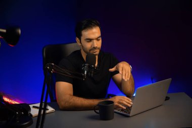 Yayıncı, fanclub dinleyicisiyle mikrofon kullanarak konuşuyor. Mor neon ışıklı modern stüdyoda yaratıcı olumlu düşünce konseptiyle canlı yayında finansal sorunları tartışıyor. Tahmin et..