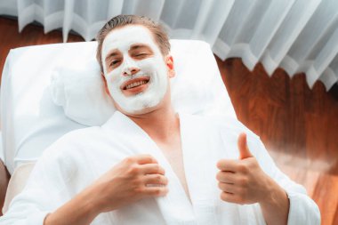 Kaplıca salonunun sakin atmosferi, insan müşterisi modern gün ışığında lüks yüz kremi masajıyla kendini yenileme zevkine kapılıyor. Yüz bakımı ve güzellik konsepti. Sessiz.