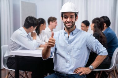 Mühendis ekip lideri portresi çeşitli inşaat mühendisi ve müvekkil gruplarıyla birlikte mimari proje üzerinde çalışıyor, inşaat planını gözden geçiriyor ve toplantı masasında proje oluşturuyorlar. Tedbirli