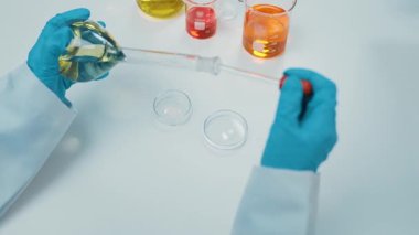 Bilimsel laboratuar araştırmacısı mikroskobik slayt üzerine sıvı örneği bırakır. Tıbbi muayene için ya da yeni teşhis aleti için. Mikrobiyolog, tıp çalışanı laboratuarda deney yapıyor. Ağır çekim. Katı.