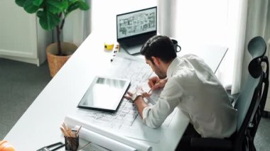 Kafkasyalı yetenekli, gevşemiş inşaat mühendisi mola zamanında elinde planla masada uzanıyor. Profesyonel mimar, dizüstü bilgisayar ve ekipman üzerinde çalıştıktan sonra uyuyor ve dinleniyor. Hizalama.