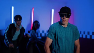 Kameranın önünde dans eden yetenekli break dansçı farklı arkadaşları pop ya da hip hop müziği dinlemek için arkada dans ediyor. Çekici performans ekibi kameraya doğru hareketli hareketler sergiliyor. Mutluluk.