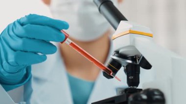 Bilimsel laboratuar araştırmacısı mikroskobik slayta kan örneği bırakır. Tıbbi muayene için ya da yeni teşhis aleti için. Mikrobiyolog, tıp çalışanı laboratuarda deney yapıyor. Ağır çekim. Katı.