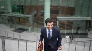 Terfi alma, satışları artırma, maaşları artırma konusunda iyi haberleri kutlamak için dans eden mutlu iş adamı şehirde geçmişi bulanık bir şekilde merdivenlerden çıkarken. Neşeli bir ruh hali. Sevinçli..