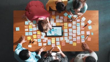 Ux Ui tasarımı kullanılarak dijital program ve yazıları tartışan ve gösteren geliştirici ekibin hava görüntüsü. İş dünyasına tepeden bakan insanlar telefon ve bilgisayar için kablo prototipi geliştiriyorlar. Sempozyum.