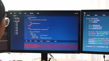 Yavaş çekim arkası yazılım geliştirici mühendisi bilgisayar programlama için birlikte çalışarak hata ayıklama kodunu çözüyor, ofiste monitörde karmaşık algoritmaları çözüyor. Filizlenen