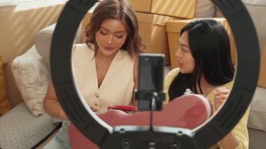 İnternette yayınlanırken gitar kılıfını gösteren ve satan mutlu bir çift. Çekici kız oturma odasında reklam ürünleri için online pazarlama kullanarak yayın yapıyor. Myrmidon.