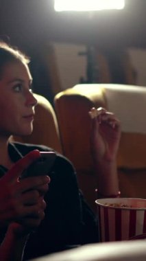 Bir adam cep telefonu oyunu oynuyor. Kız arkadaşı yanında film izlerken o oyunu kazandığı için mutlu..