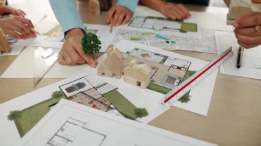 Mimarlar, mimari proje ve ölçüm araçlarının etrafa saçıldığı dağınık masa üzerindeki bina planlarını kullanarak ağaç veya evin konumunu belirlerler. İş ve çevre kavramı. Tanımlama.