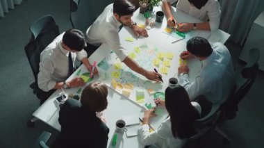 Profesyonel iş adamlarının zihin haritasını kullanarak beyin fırtınası yapmak için birlikte çalıştıklarına dair üst düzey bir görüş. Akıllı yöneticilerin sürdürülebilir enerji hakkında konuştuğu ve tartıştığı hava görüntüsü. Hizalama.
