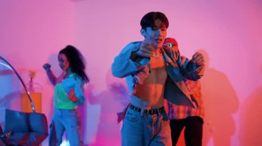 Güçlü break dans yaparken kameraya bakan enerjik Asyalı dansçı. Yetenekli insanlar dans ediyor, hareket ediyor, break dans yapıyor veya şık kıyafetler giyerken sokak dansı yapıyor. Ağır çekim. Mutluluk.