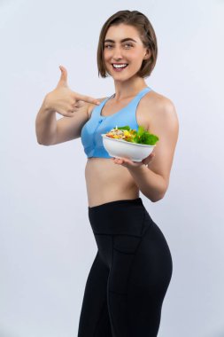 Vücut uzunluğunun tamamı atletik ve sportif, sağlıklı vejetaryen yiyeceklerle izole edilmiş arka planda duran genç bir bayanı çekiyor. Vejetaryen yaşam tarzından sağlıklı aktif ve vücut bakımı.