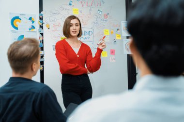 Profesyonel çekici kadın lider, modern iş toplantı odasında beyin fırtınası zihin haritalama istatistikleri ve renkli yapışkan notlar kullanarak yaratıcı pazarlama planını sunuyor. Tertemiz..