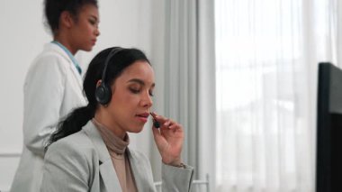 Ofiste çalışan kulaklık takan işadamları uzak müşteri ya da meslektaşlarını desteklemek için çalışıyorlar. Çağrı merkezi, tele pazarlama, müşteri destek acentesi telefon görüntülü konferans görüşmesi için hayati önem taşıyor.