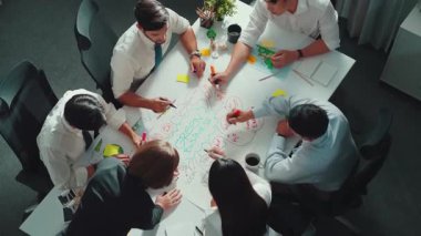 Profesyonel iş adamlarının zihin haritasını kullanarak beyin fırtınası yapmak için birlikte çalıştıklarına dair üst düzey bir görüş. Akıllı yöneticilerin sürdürülebilir enerji hakkında konuştuğu ve tartıştığı hava görüntüsü. Hizalama.