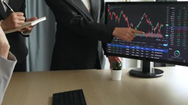 Hisse senedi borsası pazarlamasını analiz eden yavaş çekim şirketindeki yatırımcılar, kayıp için mum bar fiyatını analiz eden monitörlere bakıyor ve kazanç ve kâr elde ediyor. Filizlenen