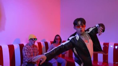 Asyalı bir adam pop müzikle dans ederken, çok kültürlü bir arkadaş evde ışık altında oturuyor. Çekici bir sokak dansçısı kameraya bakarken hip hop müzik dinliyor. Mutluluk.