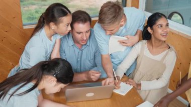 Kafkas öğretmenler dersi dizüstü bilgisayar kullanarak öğretirken öğrencilerin en üst görüşü soru sorar. Zeki eğitmen etrafını dinleyen ve ders veren çeşitli öğrencilerle çevrili olan projeyi açıklıyor. Öğretim