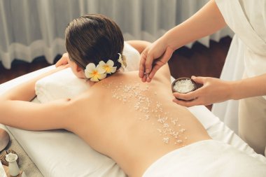 Lüks spa salonlarında sıcak mum ışığında cilt bakımı yaptıran kadın müşteri. Sağlık Spa vücut fırçasında tuz temizleme güzellik tedavisi. Sessiz.