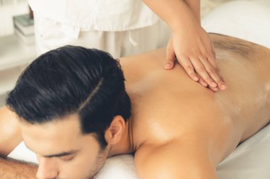 Kafkas erkek müşteri stres önleyici spa masajının keyfini çıkarıyor ve lüks otel veya oteldeki gündüz açık hava ortamında güzellik derisi eğlencesi ile şımartıyor. Sessiz.