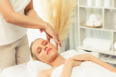 Kafkasyalı kadın stres önleyici kafa masajından ve lüks tatil beldesi ya da otel spa salonundaki modern ışık ortamında yüz güzelliği eğlencelerini şımartmaktan hoşlanıyor. Sessiz.