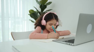 Kulaklık takıp ödevlerini yapan sevimli bir Amerikalı kız. Programlama sistemini araştırırken ve mühendislik komut yazarken defterde yazan mutlu çekici kız öğrenci. Pedagoji.