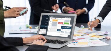 Analizci ekibi yaratıcı ve analitik beyin fırtınası fikri için bilgisayar ekranında BI veri paneli olan yapışkan bir not kullanıyor. Pazarlama stratejisi için finansal veri görselleştirme teknolojisini analiz et. Dahi.