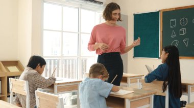 Sınıfta çeşitli çocuklar sınıf ödevlerini yaparken, Kafkasyalı öğretmen sınıfta yürüyor ve öğrenci ödevlerini kontrol ediyor. Çeşitli zeki öğrenciler ilkokulda ders veriyor ve not alıyor. Pedagoji.