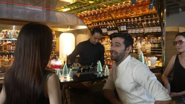 VIP grubu, barın önünde oturmuş arkadaşlarıyla ya da barmen hazırlarken karışık punç kokteyli içen çiftle yaşam tarzı seyahatlerini tartışıyor tezgahın üzerinde arka taraftaki süslü Noel ağacını hazırlıyor. Vinosity.