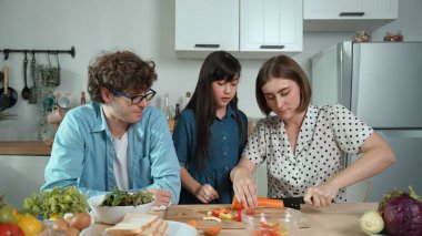 Mutlu baba yemek pişirirken müziğe geçiyor ve modern mutfakta öğle yemeği hazırlıyor. Aktif baba, sebze ve mutfak gereçleri ile çevrili sağlıklı yemek ya da salata yaparken şarkıyla dans ediyor. Pedagoji.