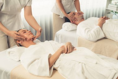 Kafkasyalı çift stres önleyici kafa masajının keyfini çıkarıyor ve lüks otellerde ya da otel spa salonlarında gündüz kaplıcalarında yüz güzelliği eğlencelerini şımartıyor. Sessiz.