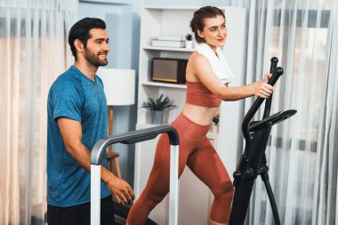 Atletik ve sportif genç çift ya da koşan makineyle koşan spor eşi, evde spor olarak vücut egzersizi yapmak. Gaiety evde egzersiz eğitimi.