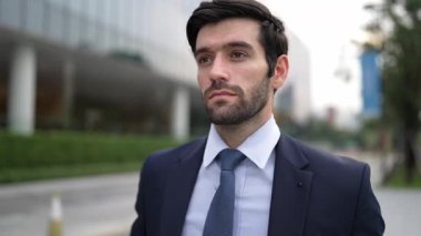Şehir manzarasında kameranın yanında yürüyen iş adamının yakın çekimi. Proje yöneticisi bulanık arkaplanlı olarak iş yerine gidiyor. Yakışıklı yatırımcı resmi takım elbise giyer, görüşmeye hazırlanır, iş görüşmesi yapar. Sevinçli..