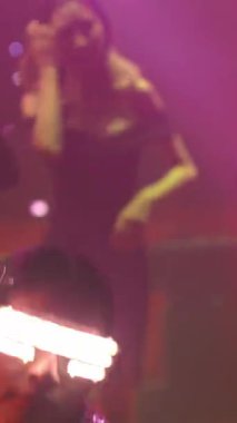 Bir grup insan disko gece kulübünde DJ 'in sahnede çaldığı müzikle dans ediyor. Yeni yıl partisi ve gece hayatı konsepti .