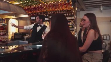 Gece kulübündeki lüks gece kulübünde, içki tezgahında çalışan akıllı barmen servisinde çift ya da arkadaş grubuyla gülen VIP müşterilere özel cin kokteyli servisi. Vinosity.