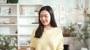 Anahtarı elinde tutan genç girişimci, merkez büroda dikilirken. Küçük işletmeleri yönetmek ya da başlamak için anahtarı taşırken kameraya özgüvenle bakan mutlu kadın satıcı. Myrmidon.