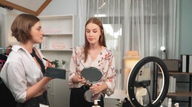 Etkilenen iki ortak canlı yayında video görüntülerini çekiyor makyaj malzemesi prim sosyal medya veya blog. Kozmetik stüdyosu ışıklandırmalı mutlu genç kız çevrimiçi pazarlama oturumu yayını için..