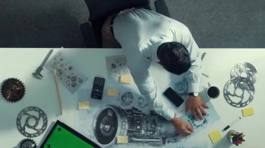 Ekipman ve elektronik jeneratörle toplantı masasında otururken, yetenekli mühendis yazma ve planlama motoru tasarımının en alt görüntüsü. Teknisyen not alıyor. Hizalama.