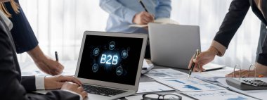 İş adamı B2B peyzajında geziniyor, iş-iş bağlantılarını geliştirmek için kullanım teknolojisi kullanıyor. B2B etkileşimini yeniden şekillendiren keşifler, iş-iş stratejilerinde yenilikleri yönlendiren araçlar. canlı