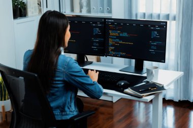 İnternet sitesi uygulamasının kodlama verileriyle birlikte online bilgi yazarak kot gömlek giyen genç Asyalı geliştirici. Güvenlik analizi ile çevrili iki ekran. Taktik.