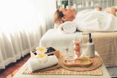 Aromaterapi masajı gündüz atmosferinde ya da spa salonunda bulanık bir kadına odak dekor ve spa aksesuarları kurarak tatil köyünde ya da otel arka planında keyifli aroma spa masajı yapan bir masaj. Sessiz.